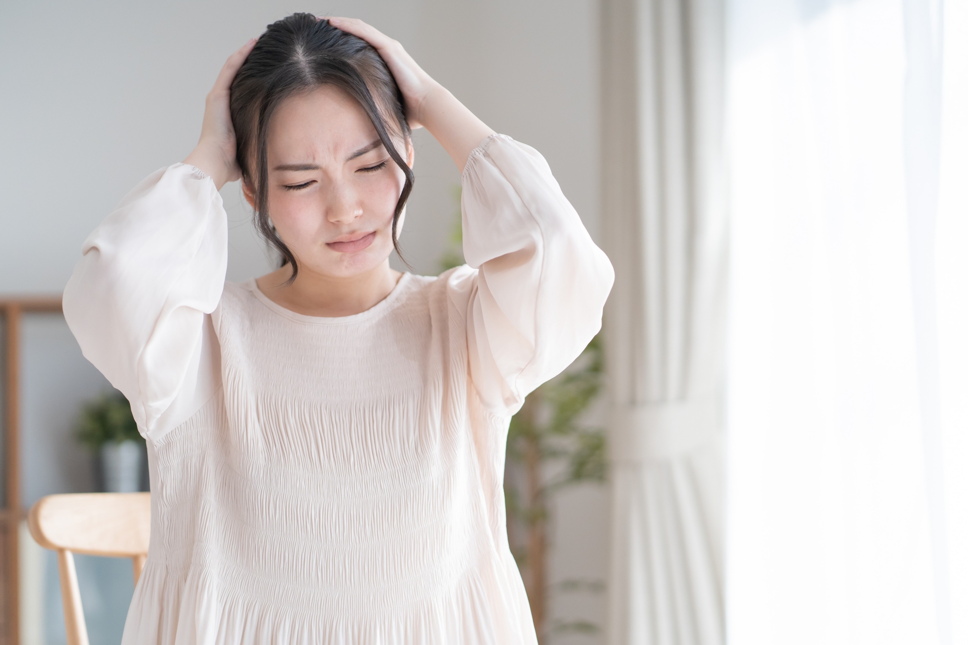 頭を抱える若い女性